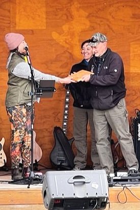 Flannery Freund, President of the North Fork Preservation Association, presents Tim Manley, retired Montana Fish, Wildlife and Parks grizzly bear biologist, with a plaque of appreciation for his dedication to the bears and residents of the North Fork valley on Saturday, May 21, 2022. (Photo: Peter Metcalf)