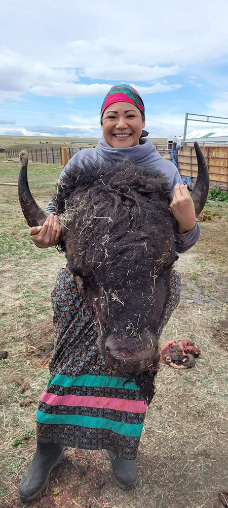 Termaine Edmo, climate change coordinator for the Blackfeet Nation, posing with a bison head