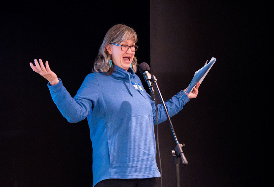 President Gina Rink speaking animatedly at the microphone