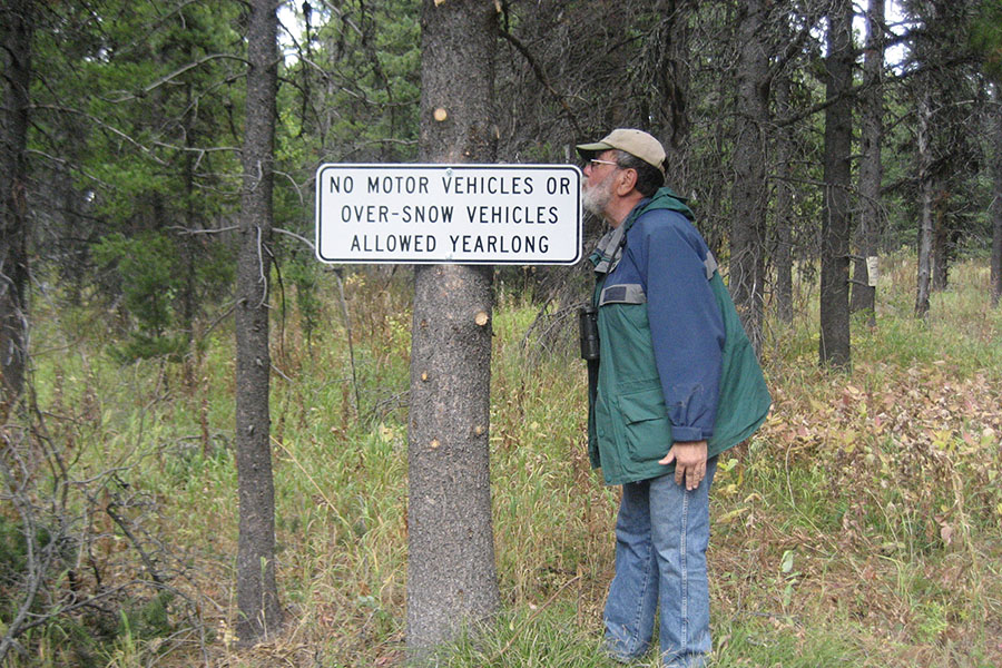 Co-founder Lou Bruno kissing a sign prohibiting motorized vehicles