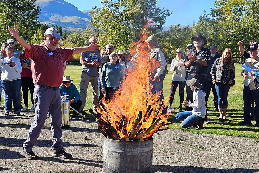 GTMA board member Lou Bruno burning oil survey stakes while onlookers cheer