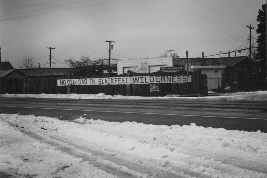 Black-and-white photo of a banner protesting oil drilling