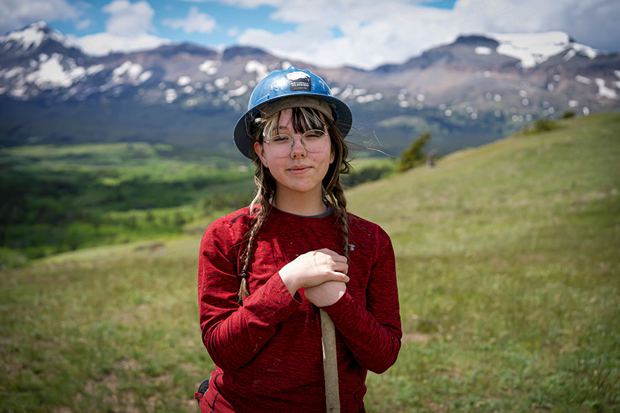 A young woman volunteer poses wearing a hard hat